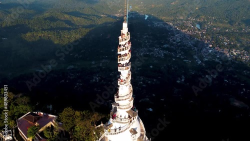 Aerial tilt up and down of Ambuluwawa Tower with tourists on stairs, Sri Lanka photo