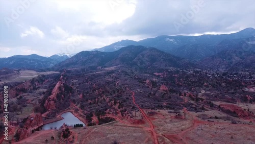 Drone shot of a lake in Manitou Springs Colorado with mountains behind it.