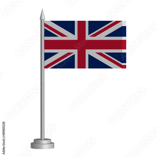 Flag of United Kingdom flying on a flagpole stands on the table