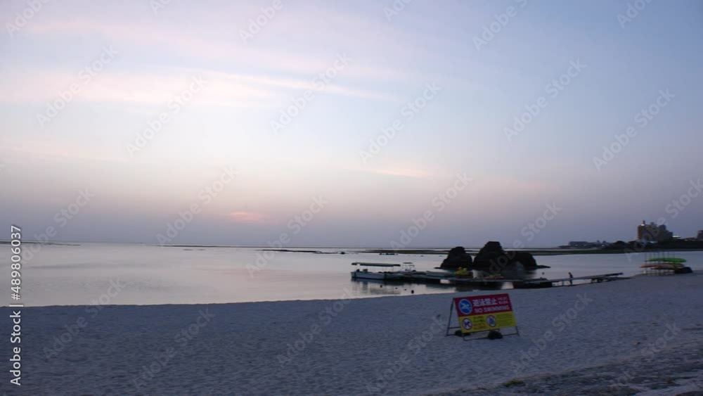 CHTAN-CHO, OKINAWA, JAPAN - AUGUST 2021 : View of Araha beach (Ocean or sea) in dusk. Sunset sky and sea. Romantic summer holiday, vacation and resort concept video. CHTAN-CHO, OKINAWA, JAPAN - AUGUST 2021 : View of Araha beach (Ocean or sea) in dusk. Sunset sky and sea. Romantic summer holiday, vacation and resort concept video.