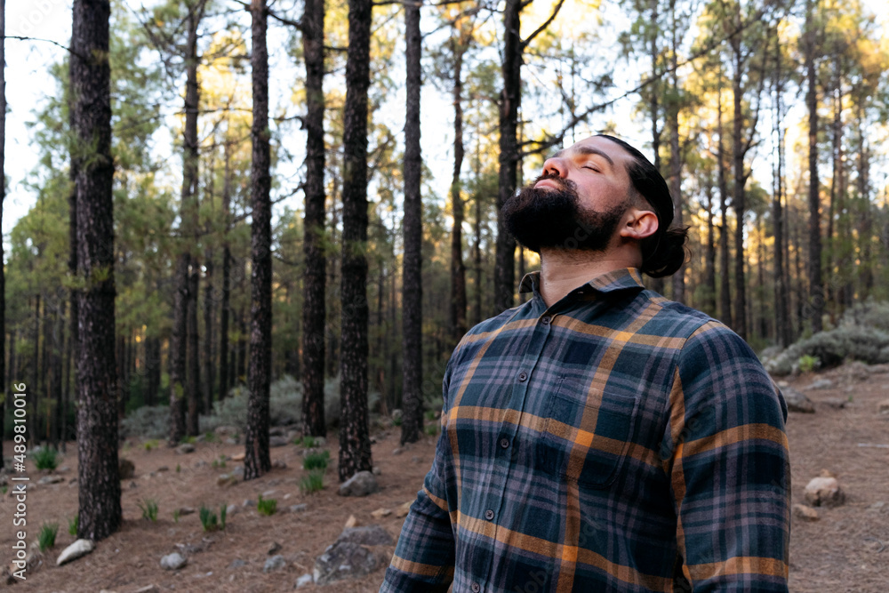 Bearded man with eyes closed standing in forest Bearded man with eyes closed standing in forest