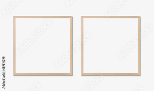 Picture frame mockup. Set of two square oak wooden frames on white wall. Template for artwork, painting or poster.