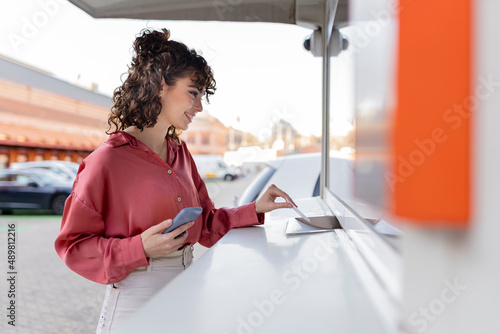 Young woman showing ticket at check-in counter photo