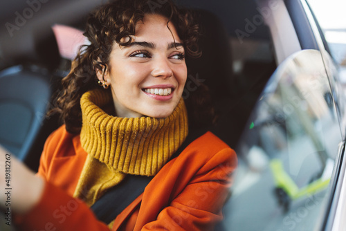 Smiling woman looking through window of car photo