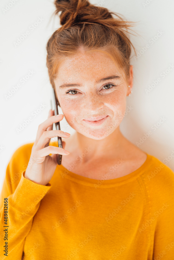 Smiling woman talking on smart phone in studio Smiling woman talking on smart phone in studio