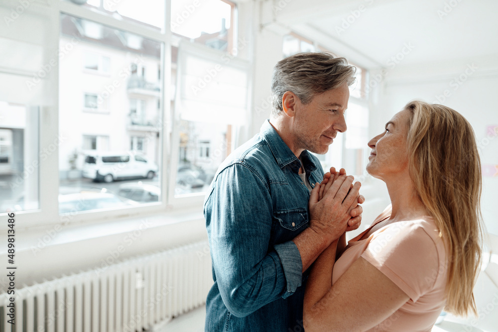 Smiling man holding woman's hands at home Smiling man holding woman's hands at home