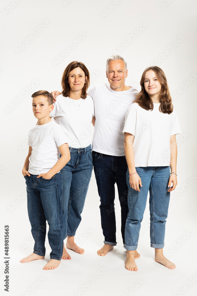 Smiling parents with son and daughter standing in studio Smiling parents with son and daughter standing in studio