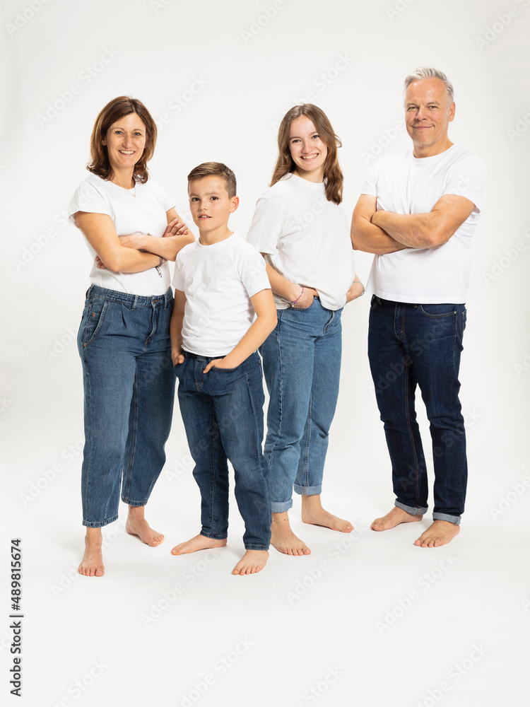 Children standing with hands in pocket with parents arms crossed at studio Children standing with hands in pocket with parents arms crossed at studio