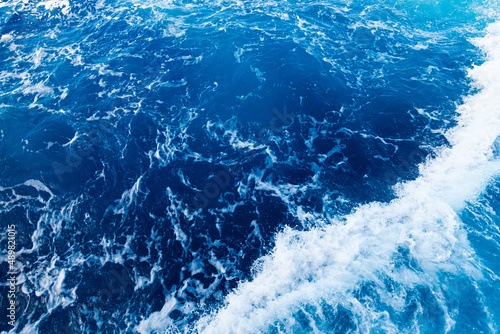 Rolling waves in the ocean. Blue water background with white foam. Rushing water in the open sea. © Сергей Жмурчак