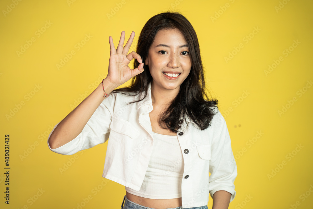 beautiful Young asian woman smiling with okay hand gesture