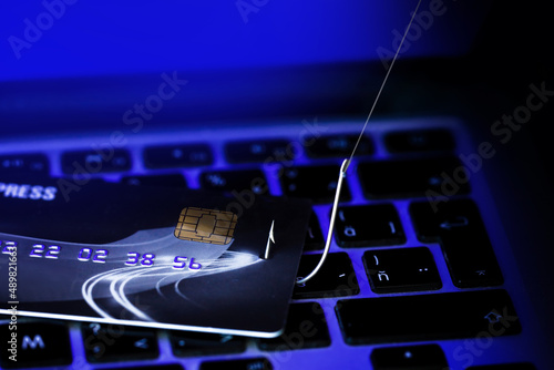 Photos Phishing Credit Cards - Piles of credit cards with fish hook on computer keyboard