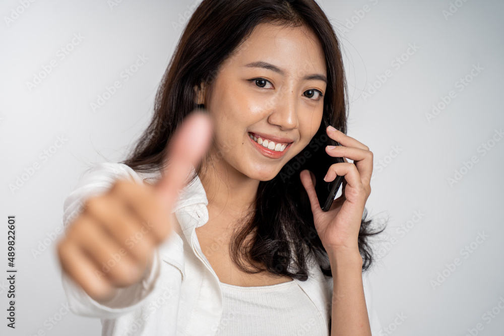 woman making a call using a mobile phone with thumbs up