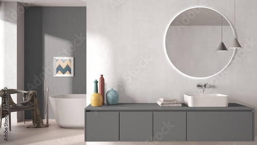 Cozy minimalist bathroom in gray and pastel tones  washbasin with mirror  bathtub  tiles and concrete walls  armchair  colored vases and decors  interior design project concept idea