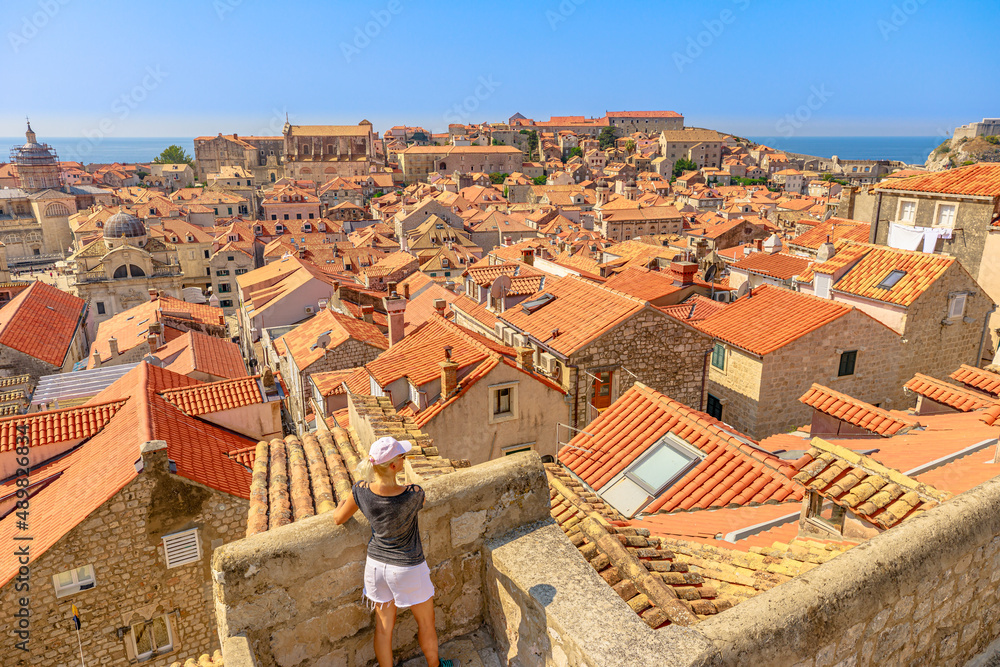 Aerial view of a girl on Dubrovnik walls in Croatia. View of Fort Lovrijenac fortress and church Crkva sv. Vlaho Saint Biagio of Dubrovnik UNESCO Venetian town of Croatia in Dalmatia