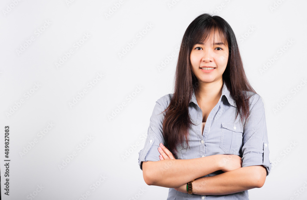 Woman standing her smile confidence with crossed arms isolated white background, Asian happy portrait beautiful young Thai female looking to camera in studio shot on white background and copy space Woman standing her smile confidence with crossed arms isolated white background, Asian happy portrait beautiful young Thai female looking to camera in studio shot on white background and copy space