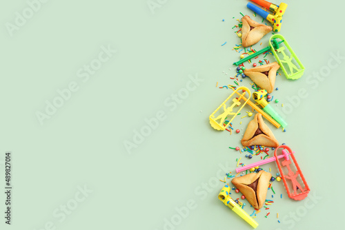 Purim celebration concept (jewish carnival holiday) over green background. Top view, flat lay