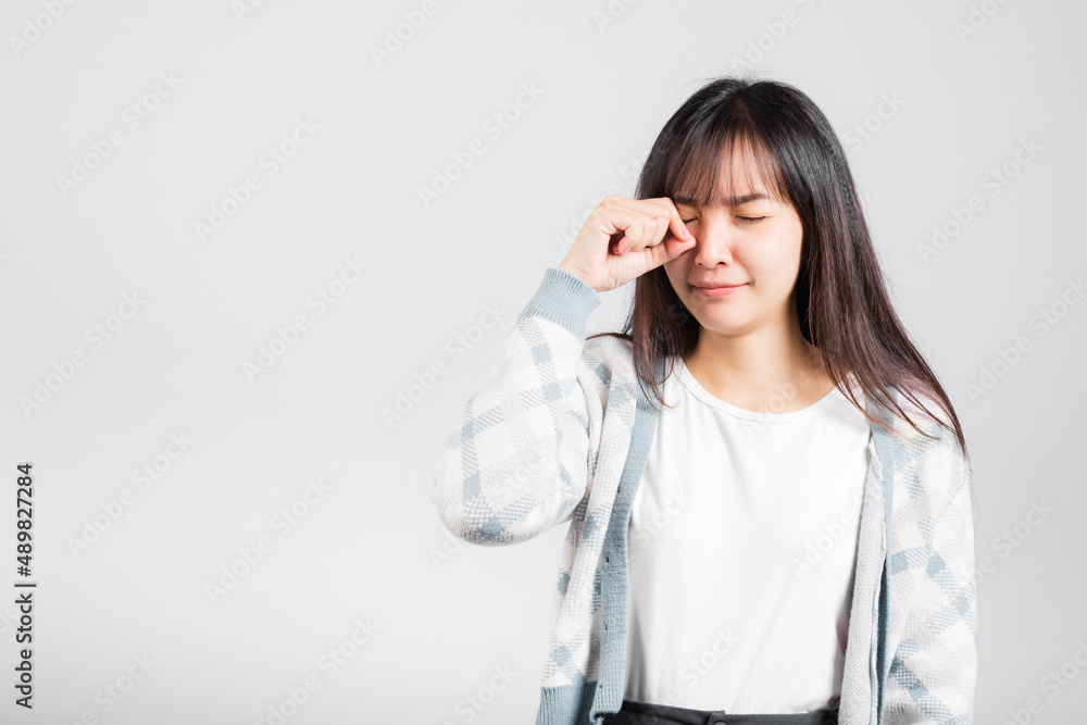 Unhappy woman bad mood her cry wipe tears with fingers, Asian beautiful young female stress feeling sad unhappy crying, studio shot isolated on white background with copy space Unhappy woman bad mood her cry wipe tears with fingers, Asian beautiful young female stress feeling sad unhappy crying, studio shot isolated on white background with copy space