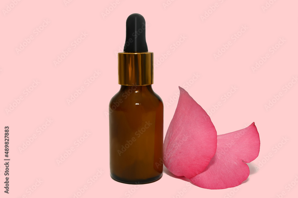 Bottle with dark glass with rose petal cosmetic oil. Bottle with dark glass with rose petal cosmetic oil.