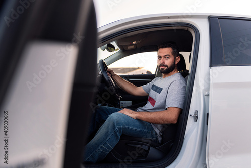 young man looking at camera sitting in his car