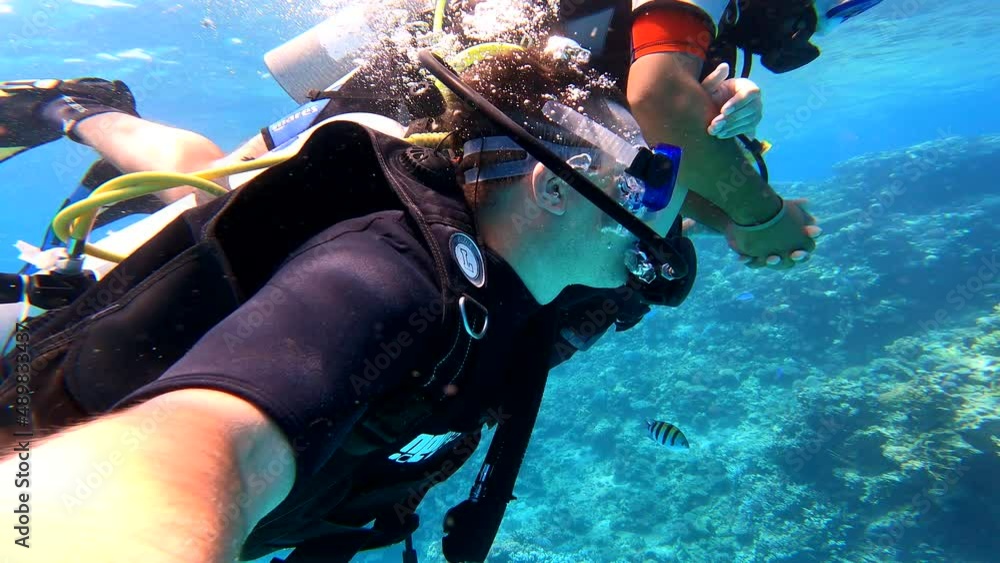 Three men scuba-dived into the sea in search of a coral reef. Scuba divers in the sea.