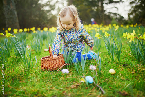 Sticker Three year old girl playing egg hunt on Easter