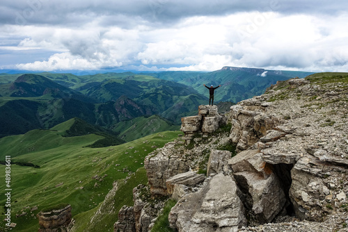 A man on the background of the mountains and the Bermamyt plateau in Russia. June 2021