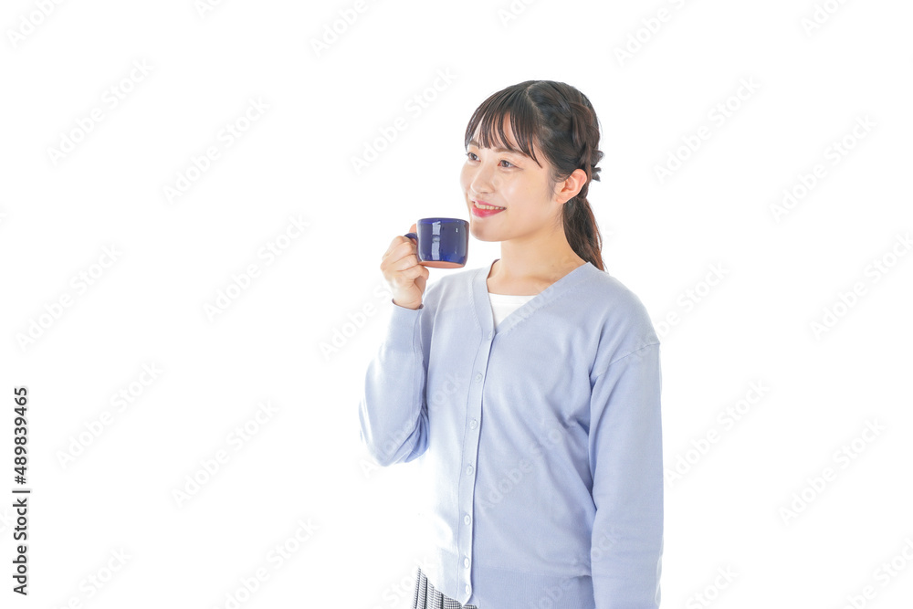 マグカップでコーヒーを飲む若い女性