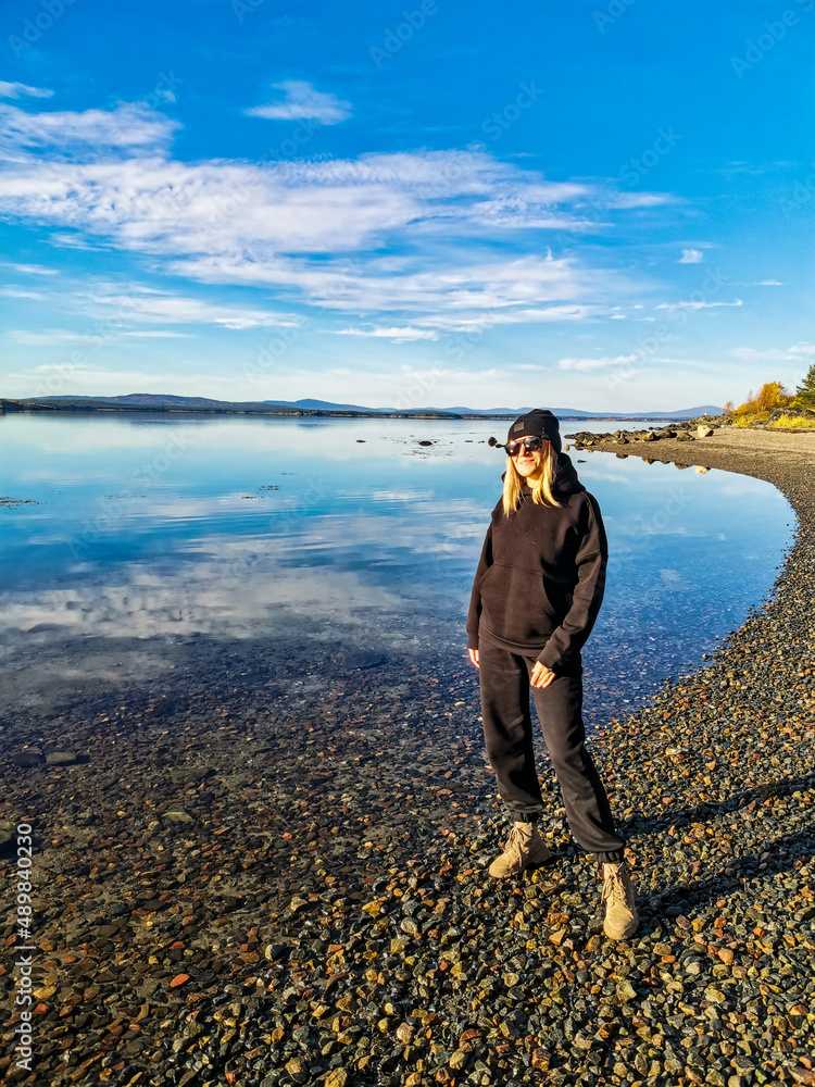 A girl on the White Sea coast on a sunny day. Karelia. Russia. SEPTEMBER 2021