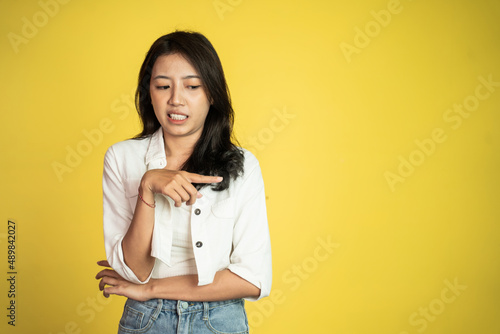 asian woman feeling disgusted and pointing at something