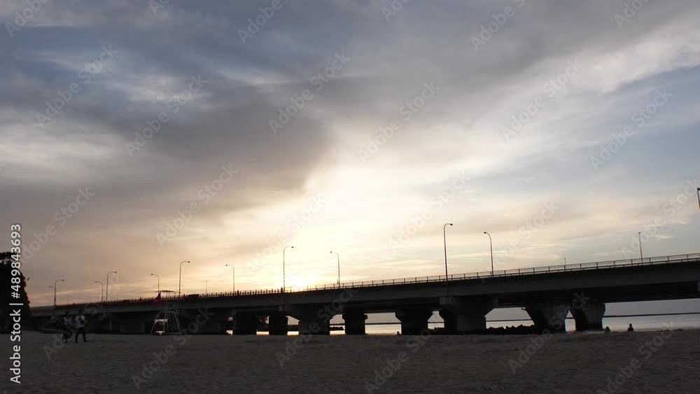 NAHA, OKINAWA, JAPAN - AUG 2021 : View of Naminoue beach (Ocean or sea) and road traffic in sunset time. Wide view, time lapse shot, dusk to night. Summer holiday, vacation and resort concept shot. NAHA, OKINAWA, JAPAN - AUG 2021 : View of Naminoue beach (Ocean or sea) and road traffic in sunset time. Wide view, time lapse shot, dusk to night. Summer holiday, vacation and resort concept shot.