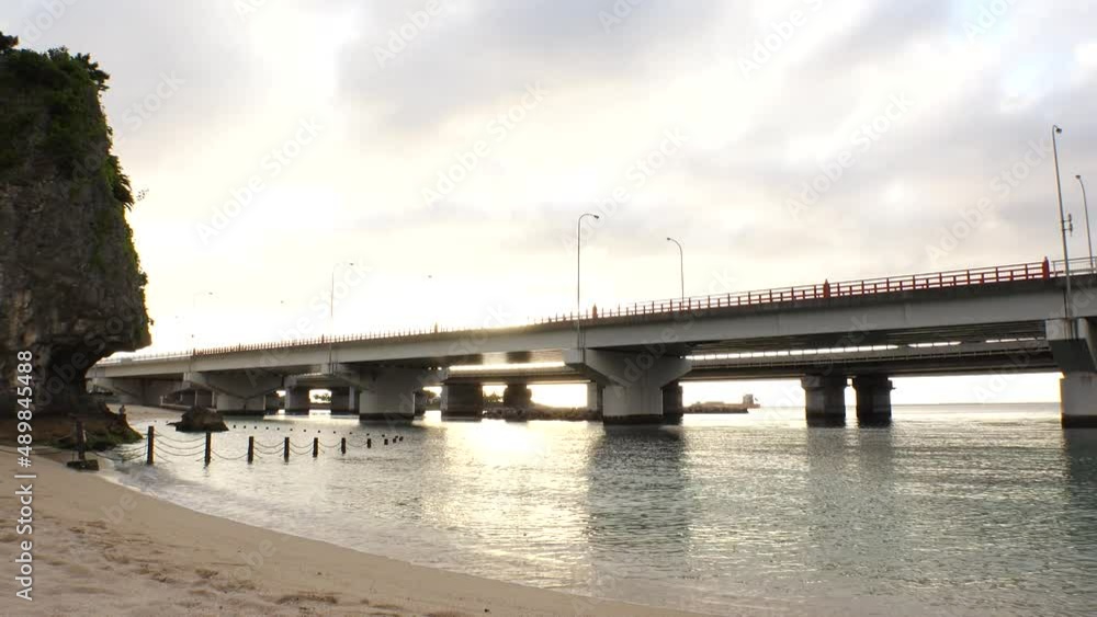 NAHA, OKINAWA, JAPAN - AUG 2021 : View of Naminoue beach (Ocean or sea) and road traffic in sunset time. Wide view, time lapse shot, dusk to night. Summer holiday, vacation and resort concept shot. NAHA, OKINAWA, JAPAN - AUG 2021 : View of Naminoue beach (Ocean or sea) and road traffic in sunset time. Wide view, time lapse shot, dusk to night. Summer holiday, vacation and resort concept shot.