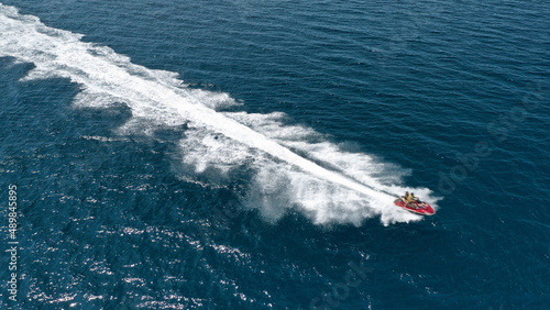 Aerial photo of jet ski with couple cruising in high speed in Caribbean tropical crystal clear deep blue waters
