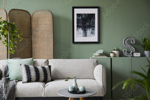 Εκτύπωση καμβά Elegant living room interior design with mockup poster frame, modern grey sofa, wooden commode, folding screen, plants and stylish accessories