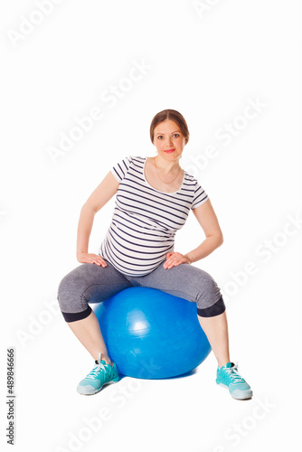 Pregnancy exercise concept - pregnant woman doing exercises with exercise ball isolated on white background