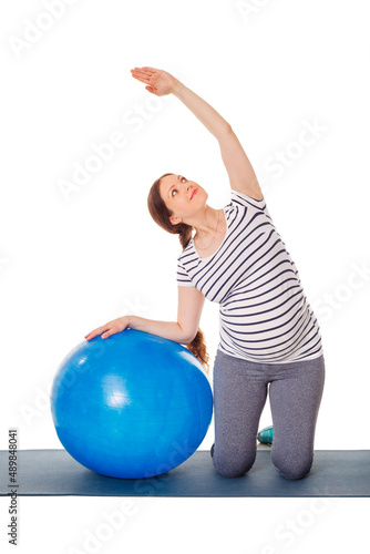 Pregnancy exercise concept - pregnant woman doing exercises with exercise ball isolated on white background