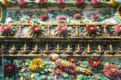 Fototapeta Naklejka Na Ścianę i Meble -  Golden Pattern at Wat Pho in Bangkok, Thailand with Floral Design of shapes and color. Vintage thai golden pattern with gems. Asian golden ornament in Thailand. Traditional decorative background