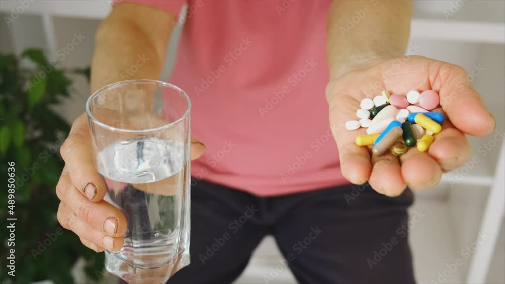 An old woman is drinking pills. Selective focus. An old woman is drinking pills. Selective focus.
