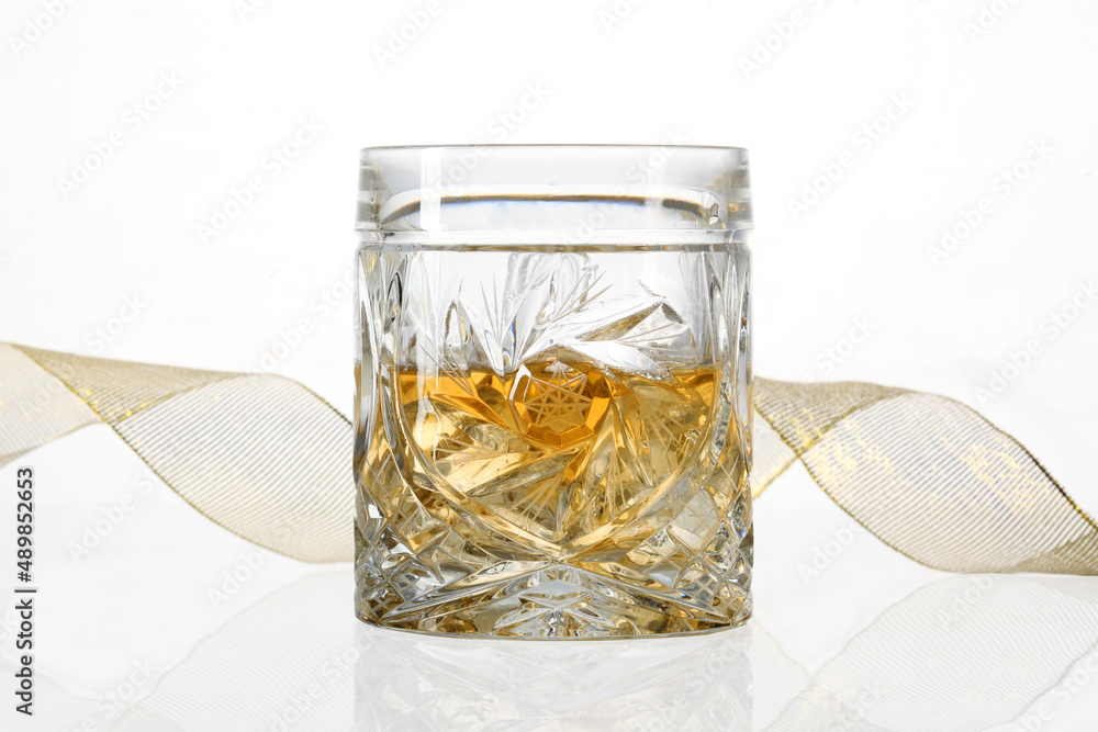 Glass of whiskey with a yellow ribbon isolated ano whithe background with copy space for your text Glass of whiskey with a yellow ribbon isolated ano whithe background with copy space for your text