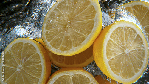 Fresh lemons falling into w...