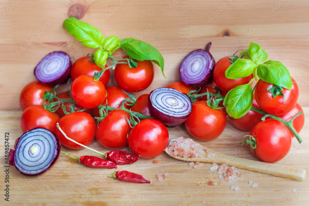 Ingredients for Arrabiata Sause .Cherry Tomatoes, Red Onion ,Chili peppers and Basil on a Wooden Background Ingredients for Arrabiata Sause .Cherry Tomatoes, Red Onion ,Chili peppers and Basil on a Wooden Background