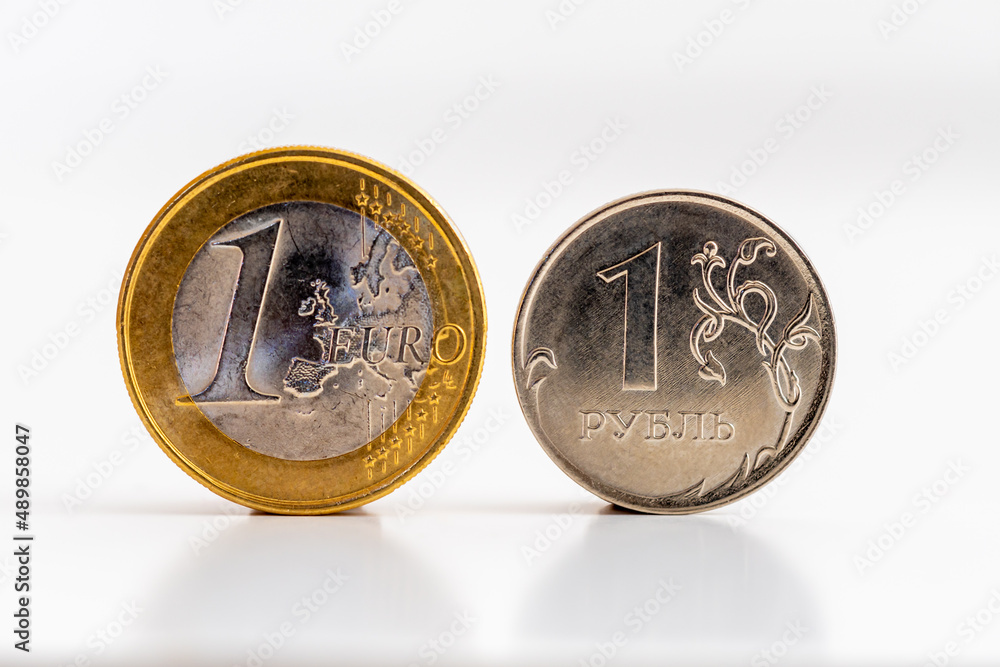 Pièces de 1 euro et de 1 rouble sur fond blanc. Concepts de taux de ...