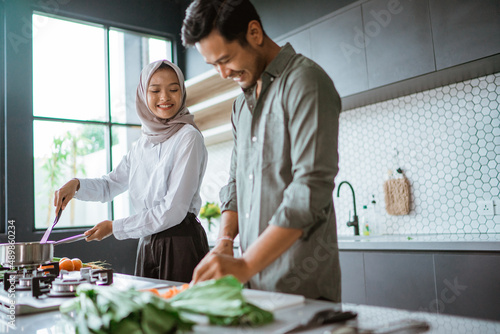romantic young muslim couple have fun making food at home