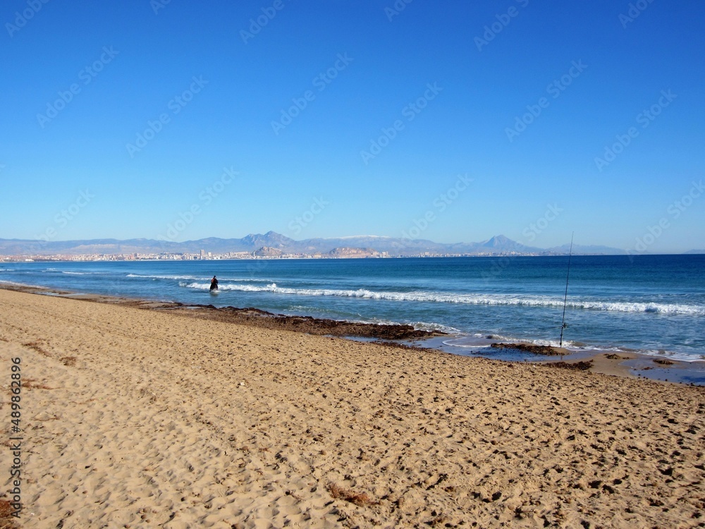 beach with horse and rider and fishing rod