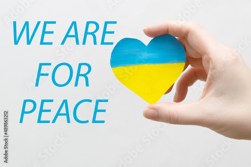 The concept of ending the war in Ukraine. heart in the colors of the flag of Ukraine in female hands.