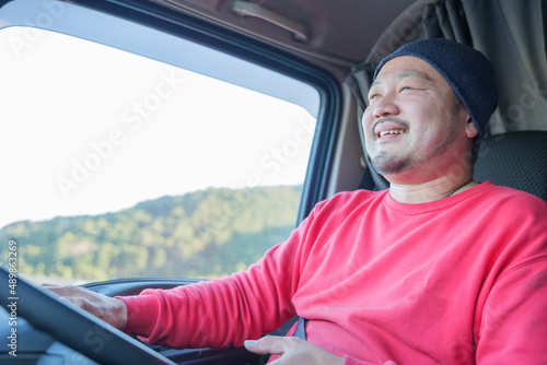 大型トラックを運転している笑顔の男性ドライバー