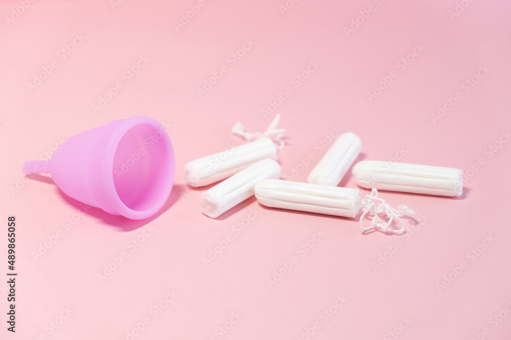 Menstrual cycle. Alternative means of hygiene and protection in critical days for women.Tampons or silicone menstrual cup on pink background. Сoncept : reuse, eco, safety. Selective focus. Menstrual cycle. Alternative means of hygiene and protection in critical days for women.Tampons or silicone menstrual cup on pink background. Сoncept : reuse, eco, safety. Selective focus.