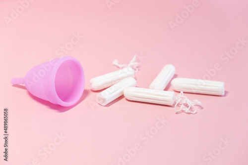 Menstrual cycle. Alternative means of hygiene and protection in critical days for women.Tampons or silicone menstrual cup on pink background. Сoncept : reuse, eco, safety. Selective focus. 