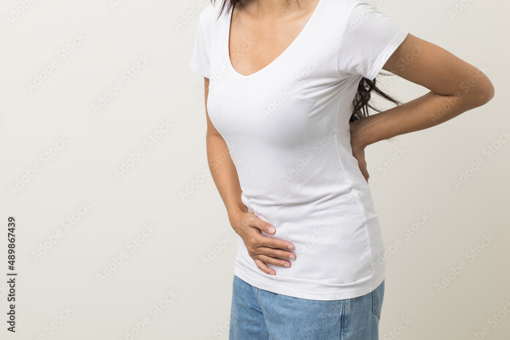 A woman had a stomach ache and gastritis. She put her hand on her stomach and squeezed it to relax and soothe. She is 25 years old and has menstrual cramps. Shot on isolated white background. A woman had a stomach ache and gastritis. She put her hand on her stomach and squeezed it to relax and soothe. She is 25 years old and has menstrual cramps. Shot on isolated white background.