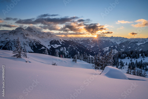 Sonnenuntergang in den verschneiten Bergen photo