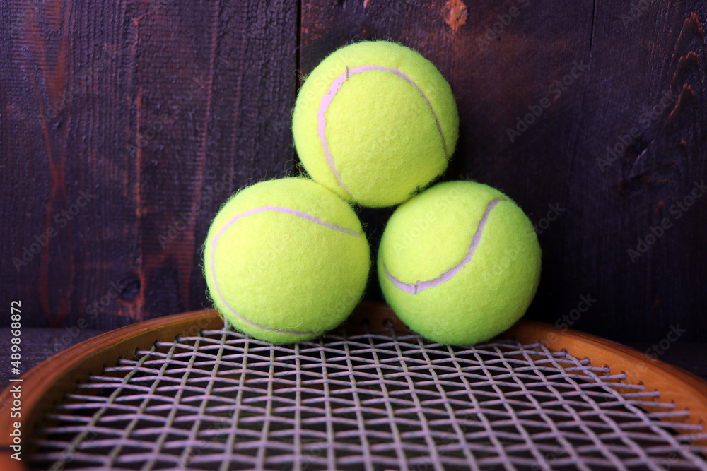 Vintage wooden tennis racquet and balls.